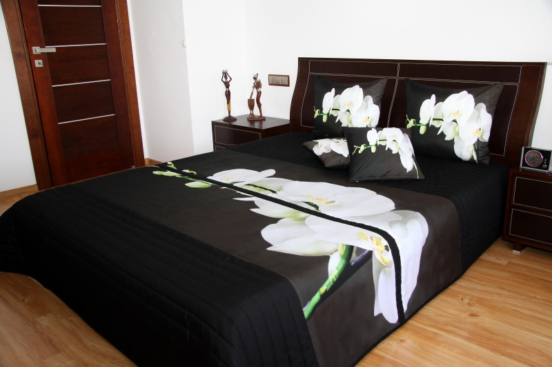 Narzuta koloru czarnego na łóżko sypialniane z białą orchideą 