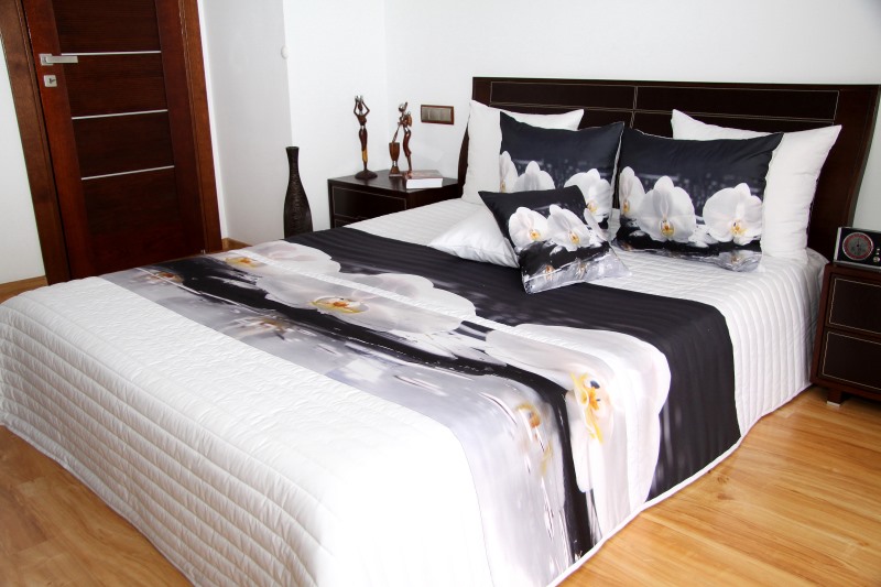 Narzuty pikowane na duże łóżka w kolorze białym z czarnym tłem i białymi kwiatam