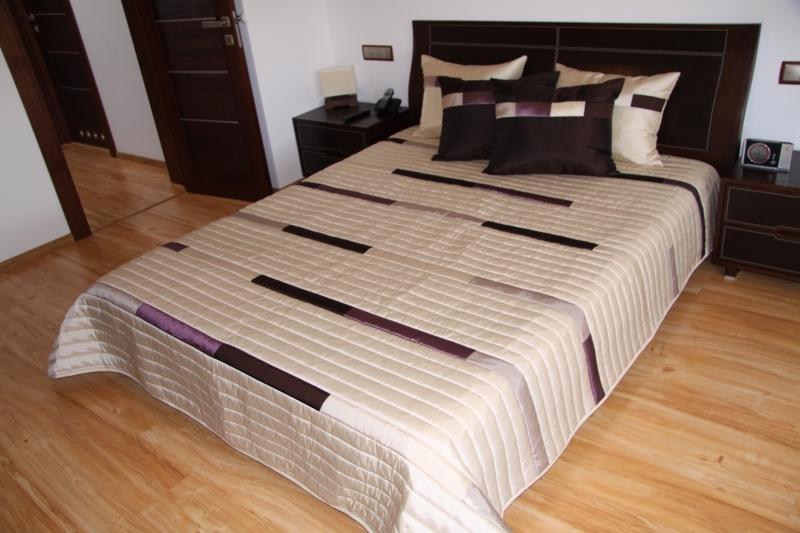 Beżowe narzuty luksusowe na łóżka do sypialni w fioletowe paski